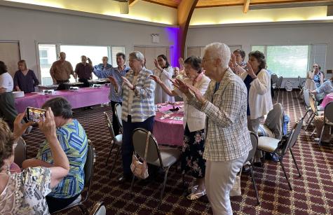 Group of Sisters standing with hands outstretched blessing Sister Henrice on 100th Birthday